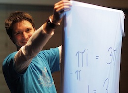 Andrew Holding holding up a poster with e^iPi on it